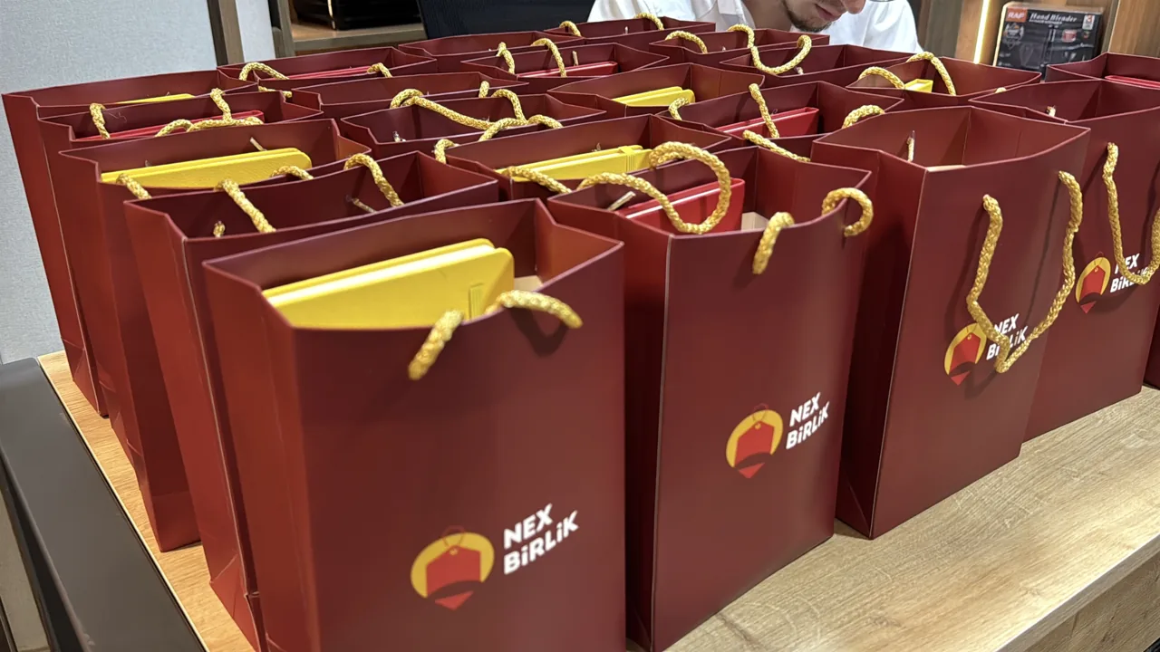 Masada düzülmüş qırmızı NexBirlik çantaları